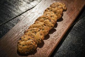 Chocolate chip cookie biscuits on rustic wooden board photo