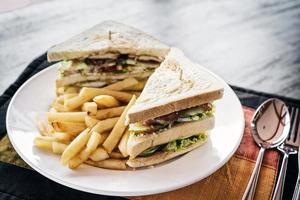 Club sandwich snack con papas fritas en la placa foto