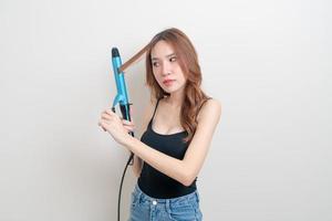 Portrait beautiful Asian woman using hair curler or curling iron photo