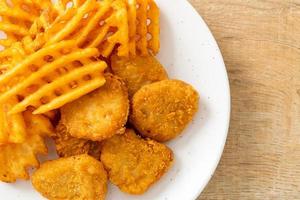 Fried chicken nuggets with fried potatoes photo