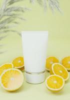 un tubo exprimidor para aplicar cremas o cosméticos, junto con naranja. foto