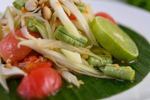 Papaya salad on a white plate on a wooden table photo