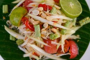 Papaya salad on a white plate on a wooden table photo