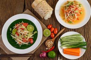 Papaya salad on a white plate on a wooden table photo