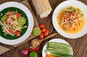 Papaya salad on a white plate on a wooden table photo