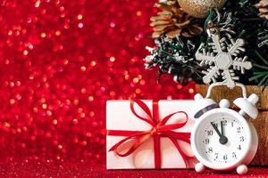 Gift boxes and alarm clock on a red glittering background. photo