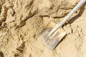 Top view shovel on sand in construction site photo