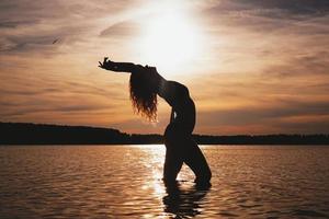 Happy Carefree Woman Enjoying Beautiful Sunset on the Beach photo