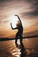 Happy Carefree Woman Enjoying Beautiful Sunset on the Beach photo