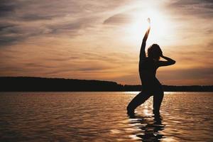 Happy Carefree Woman Enjoying Beautiful Sunset on the Beach photo