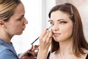 Beautiful girl put on make-up in a beauty salon photo