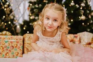 Cute little girl in pink dress with present photo