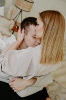 Close-up portrait of a beautiful young couple hugs in bed at home photo