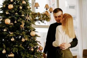 Picture showing young couple hugging over Christmas tree photo