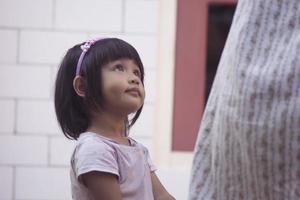 A baby girl accompanies her mother drying clothes. photo