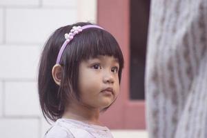 A baby girl accompanies her mother drying clothes. photo