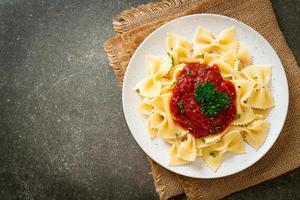 Farfalle pasta in tomato sauce with parsley photo
