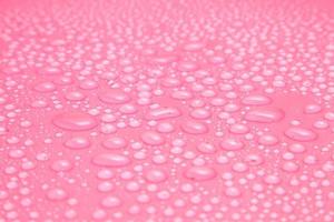 Close up water drops on pink background photo