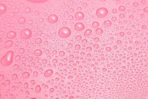 Close up water drops on pink background
