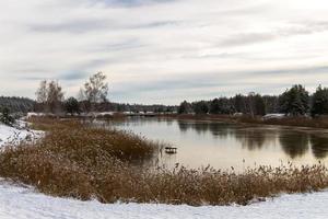 View from the shore of the river covered with thin ice photo