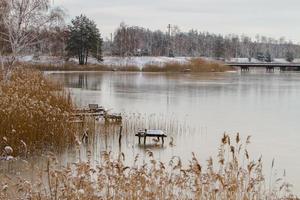 View from the shore of the river covered with thin ice in winter photo