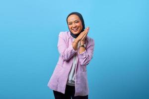 Cheerful beautiful Asian woman rub hands over blue background