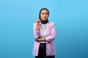 Attractive Asian woman raising index finger and saying her idea photo