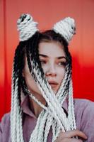 Portrait of beautiful cool girl over red wall photo