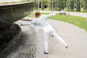 Woman standing by the fountain in the park photo