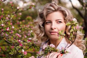 mujer joven romántica en el jardín de primavera entre flor de manzano. foto