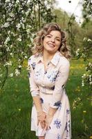 Hermosa mujer joven en el jardín de la manzana en un día soleado de primavera foto