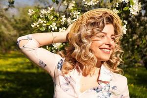 Sonriente mujer de verano con sombrero de paja en el parque