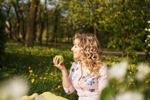 Mujer con manzana en un picnic en el jardín de verano