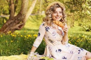 Woman with a croissant on a picnic photo