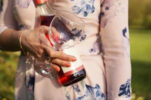 Beautiful young woman holding a blank bottle of wine photo