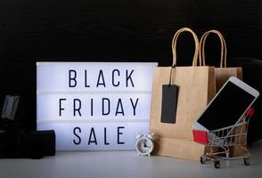 palabras de venta de viernes negro en caja de luz con etiqueta de precio negra y regalos foto