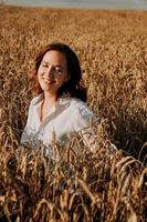 Summer nature, happy young woman in the ears of a rye field