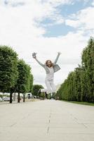 Pretty young woman jumping in the park photo