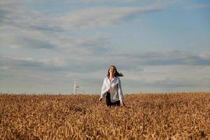 mujer corre en un campo de trigo en un día de verano. concepto de felicidad y alegría foto