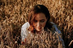 Woman in a rye field. She breathes in the scent of fresh ears