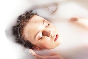 Young attractive woman relaxing in bath photo