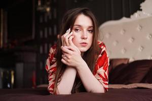 Relaxed woman lying on a brown bed thinking deeply photo