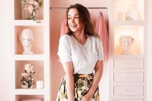 Happy young woman dressing up. Dressing room in pink photo