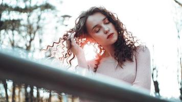 Closeup of a beautiful young woman with a sunset behind her photo