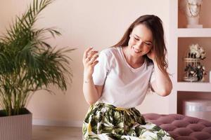 Beautiful young woman with bottle of perfume at home - dressing room photo