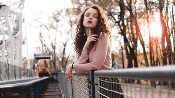 Closeup of a beautiful young woman with a sunset behind her photo