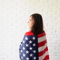 Beautiful young woman with American flag, rear view photo