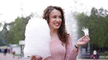 Smiling excited girl holding cotton candy at amusement park photo
