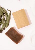 Vista superior del jabón hecho a mano y caja artesanal con hojas de eucalipto foto