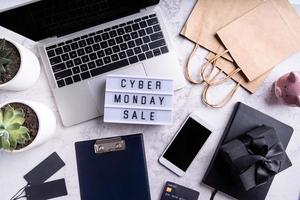 Cyber monday sale text on lightbox, top view of workspace flat lay photo